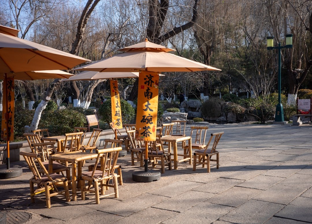 Outdoor cafe terrace with tables and a large patio umbrella providing shade