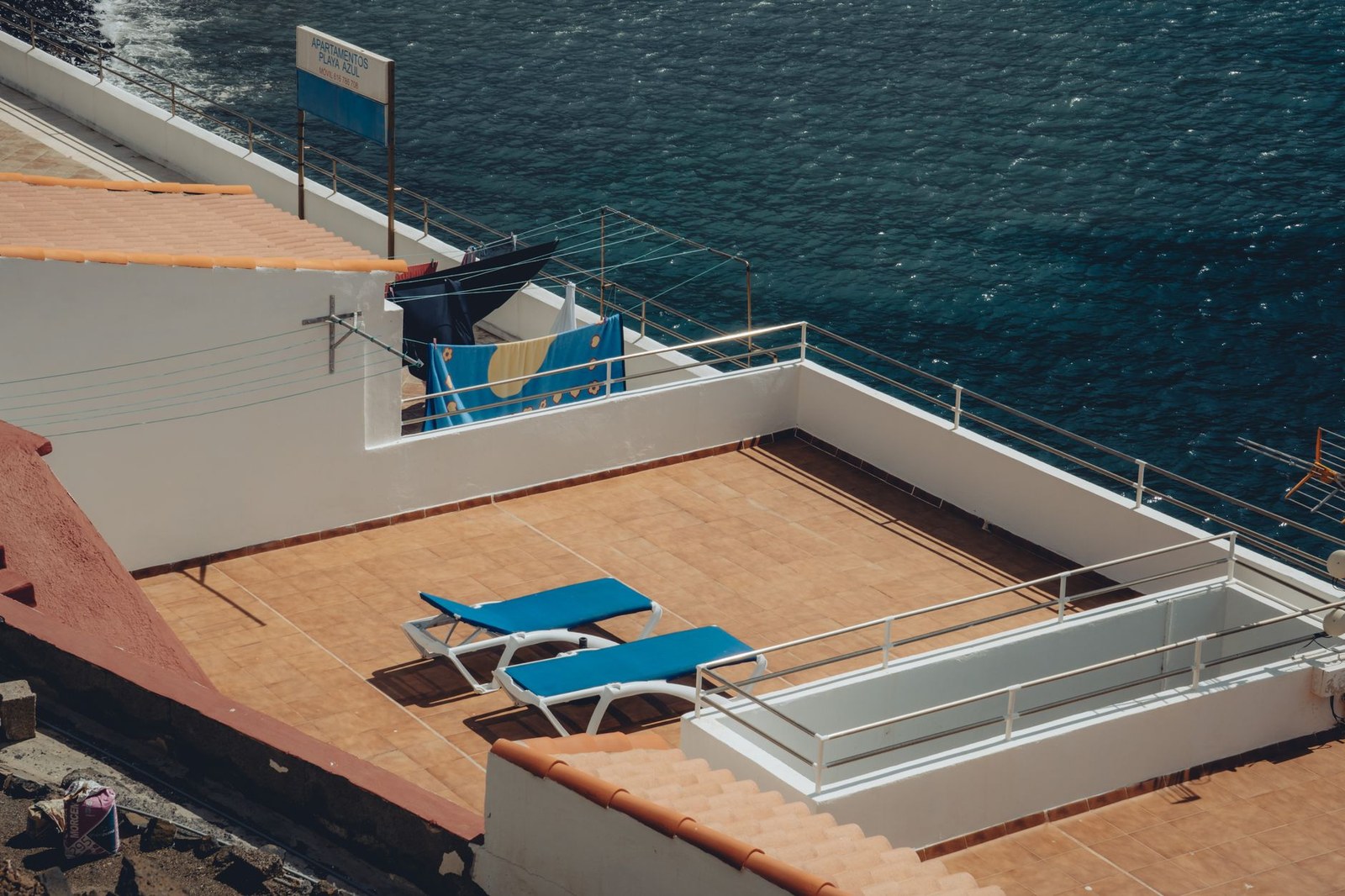 Hospitality outdoor furniture from a China factory: sun loungers and tables on a hotel rooftop terrace