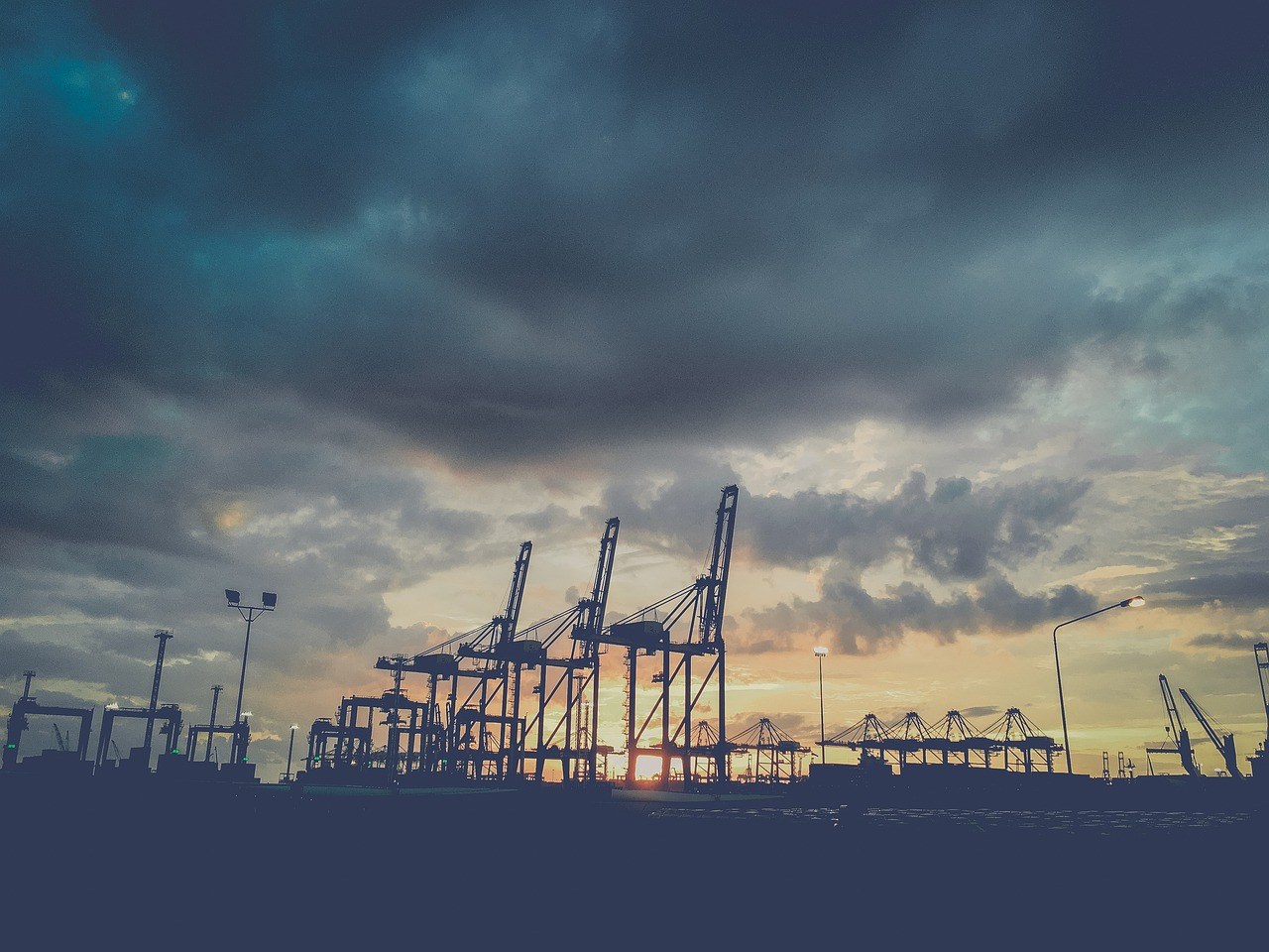 Grúas de muelle y contenedores en un puerto de exportación al atardecer