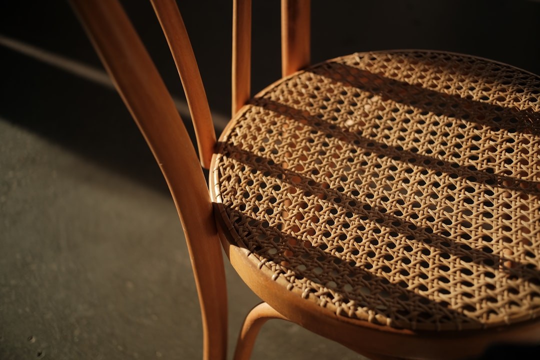 Primer plano del asiento de una silla con tejido de ratán trenzado, detalle del material de exterior