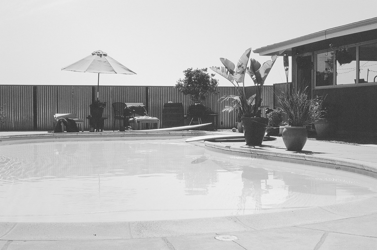 Backyard pool patio with a shade umbrella and outdoor seating