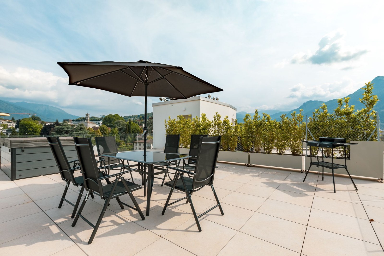 Sunny terrace with outdoor furniture under a shade umbrella
